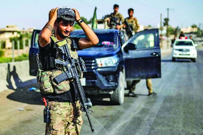 A Syrian Democratic Forces fighter with his colleagues in Syria’s northeastern Deir Ezzor province. (AFP)