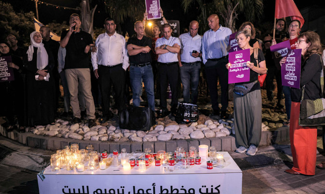 Arab and Jewish Israelis gather with placards before candles during a vigil against violence in the Arab community in the town of Basmat Tabun in northern Israel on September 27, 2023. (AFP)