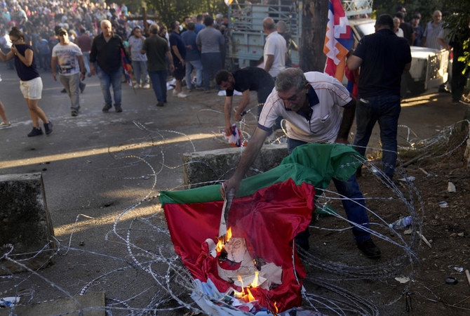 A Lebanese-Armenian protester burns Turkish and the Azerbaijani flags near the Azerbaijani Embassy, during a protest in Ain Aar, east of Beirut, Lebanon on Sept. 28, 2023. (AP)