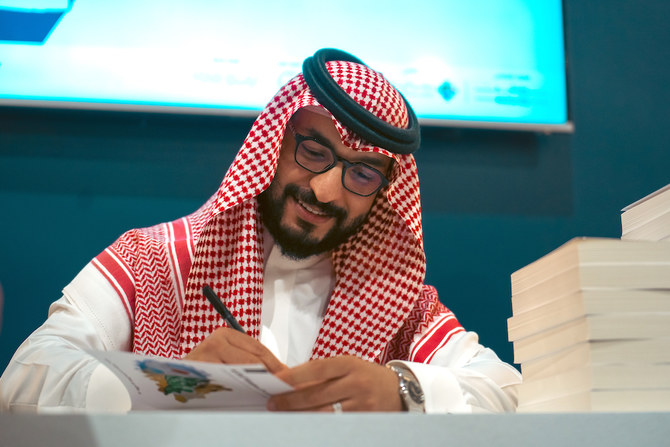 Dr. Khalid Alrashoud signs copies of his book at ongoing Riyadh International Book Fair. (Abdulrahman Shulhub)