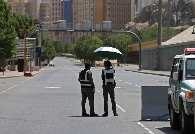 Police officers man a checkpoint in a street in Saudi Arabia's holy city of Makkah on April 3, 2020. (AFP)