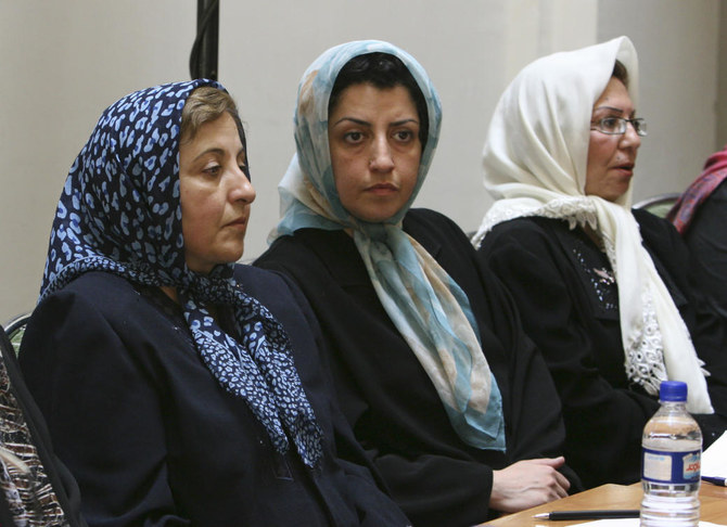 Prominent Iranian human rights activist Narges Mohammadi, center, sits next to Iranian Nobel Peace Prize laureate Shirin Ebadi, left, while attending a meeting on women's rights in Tehran (AP)