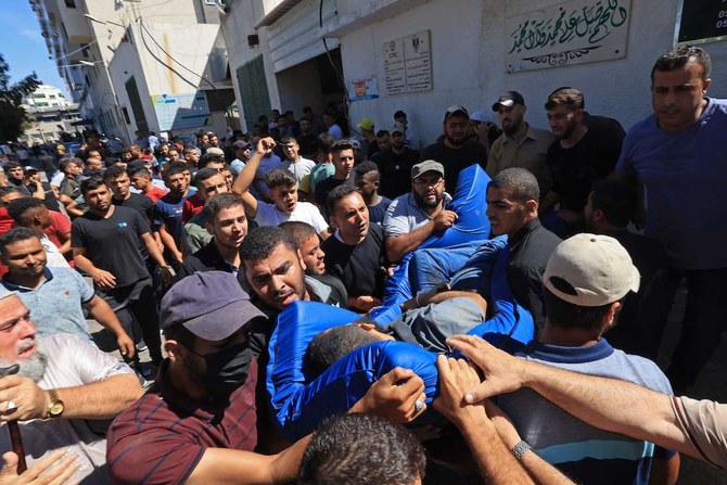 Mourners carry the body of a Palestinian killed in the latest infiltration operation into Israel, outside Aal-Shifa hospital in Gaza City on Oct. 7, 2023. (AFP)