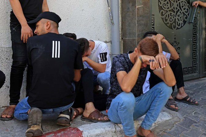 People mourn the death of Palestinians who were killed in the latest infiltration operation into Israel outside Al-Shifa hospital in Gaza City on Oct. 7, 2023. (AFP)