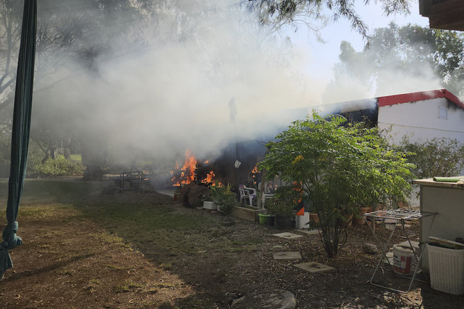 A house is on fire in the kibbutz of Kfar Azza that Palestinians stormed from the Gaza Strip on Saturday, Oct. 7, 2023. (AP)
