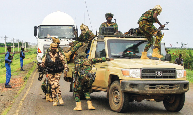 Fighters accompanying the governor of Sudan’s Darfur State exit a vehicle during a stopover in the eastern city of Gedaref. (AFP/File)