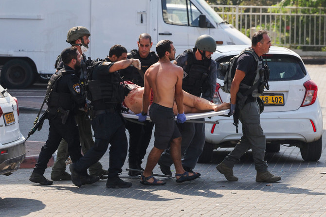 Members of Israeli security forces carries an injured person on a stretcher following a rocket attack from the Gaza Strip in Ashkelon, southern Israel, on October 7, 2023. (AFP)