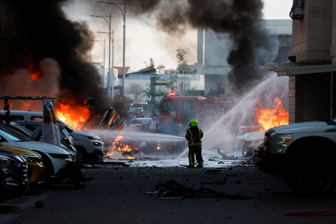 An emergency personnel works to extinguish fire after rockets launched from the Gaza Strip, as seen from the city of Ashkelon, Israel, on October 7, 2023. (REUTERS)