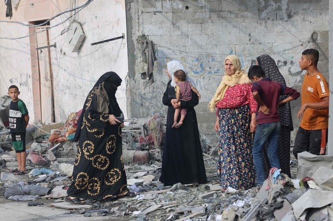 Palestinian women and children stand amid the rubble outside their homes following Israeli airstrikes on Rafah in the southern Gaza Strip, on Oct. 8, 2023. (AFP)