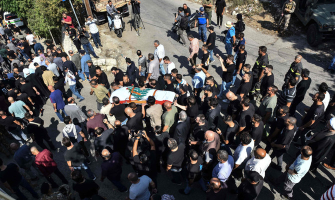 Mourners carry the casket of Lebanese Reuters video journalist Issam Abdullah, killed on October 13 by Israeli shelling at Alma Al-Shaab border village with Israel while covering cross border shelling, during his funeral in the village of El-Khiam on October 14, 2023. (AFP)