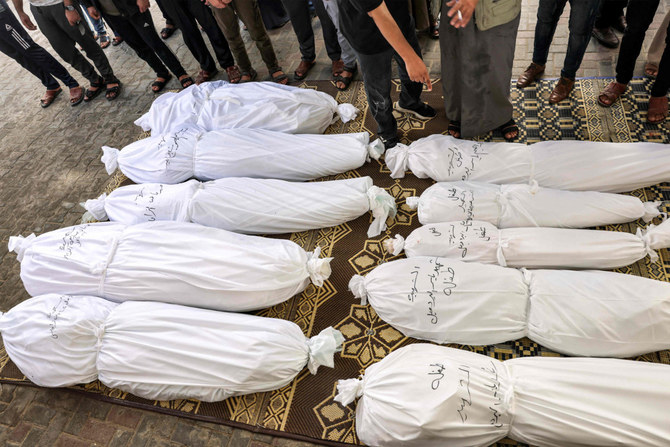 Mourners pray before the wrapped bodies of Palestinian victims who were killed in an Israeli air strike during their funeral in Rafah in the southern Gaza Strip on October 13, 2023. (AFP)