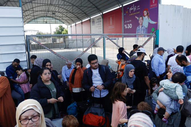 Palestinians with dual citizenship gather outside Rafah border crossing with Egypt in the hope of getting permission to leave Gaza onOct. 14, 2023. (Reuters)