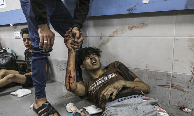 Wounded Palestinians lie on the floor in Al-Shifa Hospital in Gaza City, central Gaza Strip, after arriving from Al-Ahli Hospital following an explosion there, Tuesday, Oct. 17, 2023. (AP)