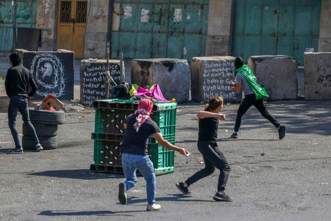 Palestinian demonstrators clash with Israeli security forces in the occupied West Bank city of Hebron on Oct. 18, 2023, following a strike which ripped through a Gaza hospital compound killing hundreds on Oct. 17, 2023. (AFP)