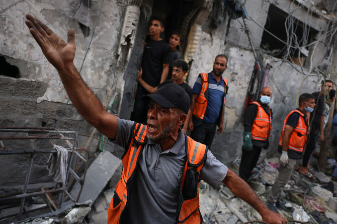 A rescuer reacts during the search for victims or survivors in a car covered by the rubble of a house destroyed in an Israeli strike in Gaza. (AFP)