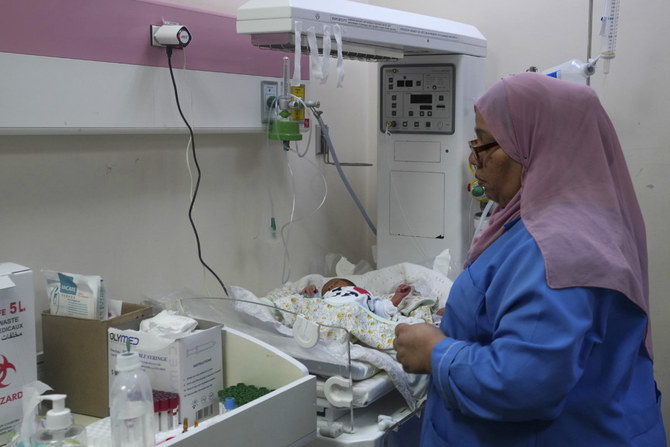 A doctor attends to prematurely born babies at Al Aqsa Hospital in Deir el-Balah, Gaza Strip, on Oct. 22, 2023. (AP Photo/Adel Hana)