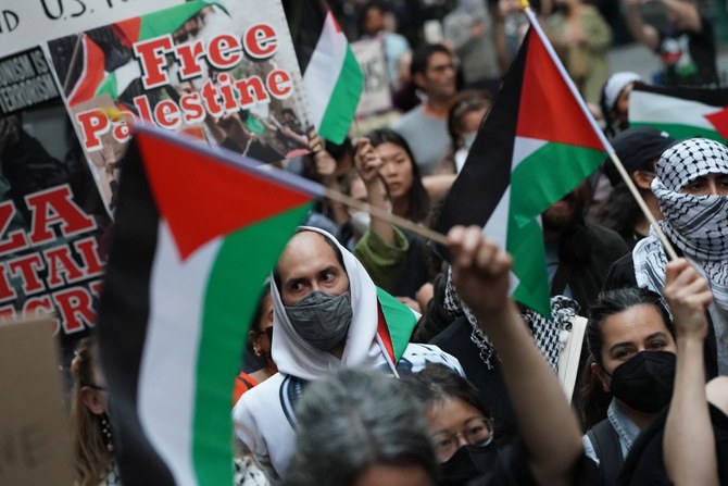 Protesters hold signs and flags during the 