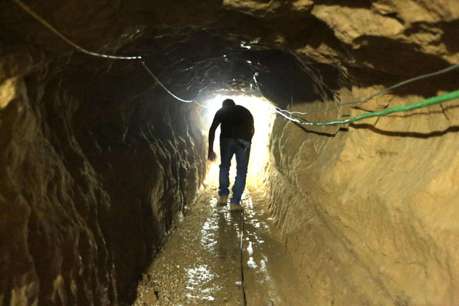 A Palestinian man walks from the Egyptian side of the border in a repaired bombed smuggling tunnel linking the Gaza Strip to Egypt, in Rafah, on November 29, 2012. (AFP/File)