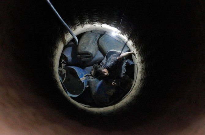 A Palestinian worker speaks to a colleague from inside a smuggling tunnel dug beneath the Gaza-Egypt border in the southern Gaza Strip on August 27, 2013. (AFP/File)
