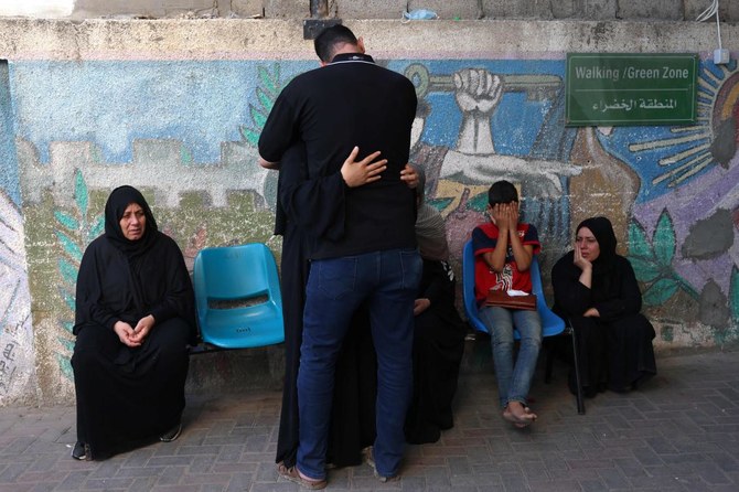 Above, Palestinian relatives wait to collect the bodies of eight family members killed in an Israeli air strike from the Najjar Hospital in Rafah in the southern Gaza Strip on Oct. 30. (AFP)