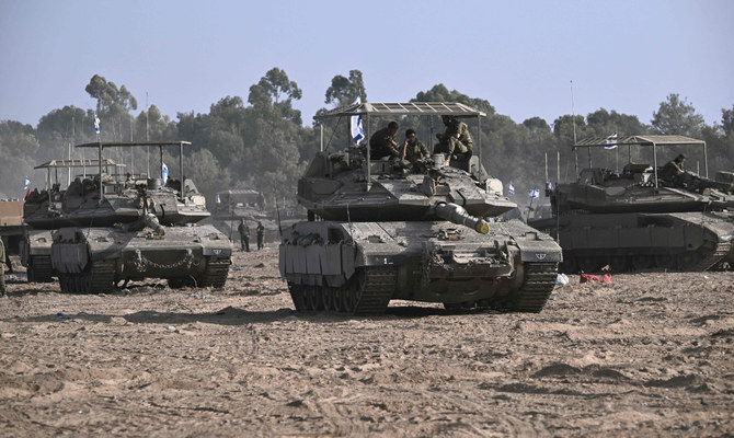 Israeli military armoured vehicles deploy along Israel's border with Gaza on Oct. 24, 2023. (AFP)