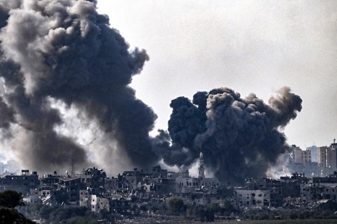 A picture taken from the Israeli side of the border with Gaza shows smoke plumes rising above buildings during an Israeli strike on the northern Gaza Strip on Oct. 14, 2023. (AFP)