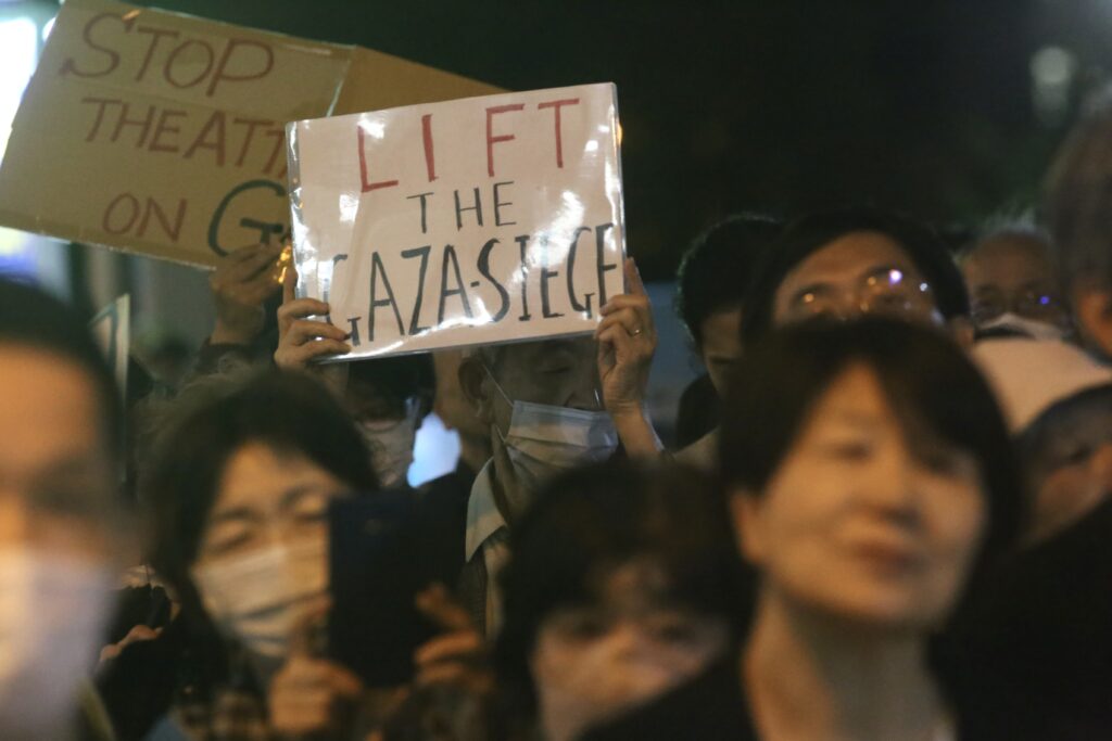 Protesters lit candles and held up signs as they chanted slogans calling for an end to the occupation and a boycott of Israel. (ANJ/ Pierre Boutier) 