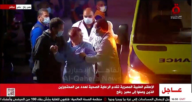 Released hostages disembark from an ambulance, as a convoy of vehicles carrying hostages abducted by Hamas militants during the October 7 attack on Israel arrives through the border crossing with Gaza. (Al-Qahera News/Reuters)