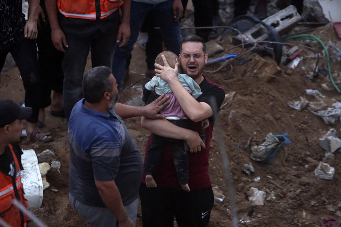 A Palestinian man cries while holding a dead child who was found under the rubble of a destroyed building following Israeli airstrikes in Nusseirat refugee camp, central Gaza Strip, Tuesday, Oct. 31, 2023. (AP)