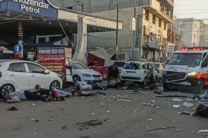 This image grab taken from an AFPTV video footage shows victims lying near an ambulance damaged in a reported Israeli strike in front of Al-Shifa hospital in Gaza City on November 3, 2023. (AFP)