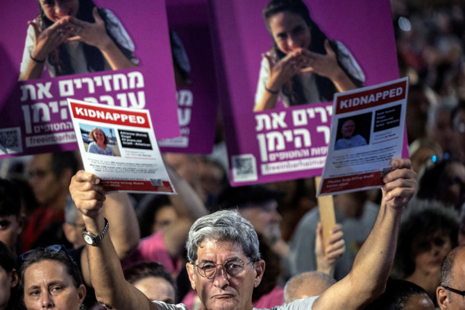 An Israeli holds pictures during a protest in Tel Aviv on November 4, 2023, to demand the immediate release of hostages held in Gaza who were seized in the October attack by Hamas gunmen. (REUTERS)