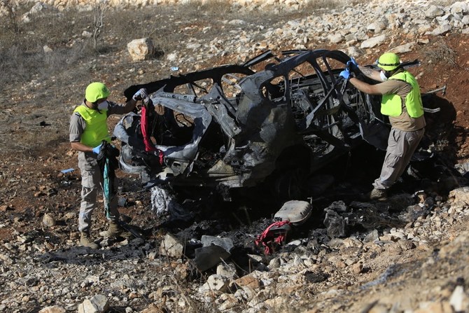 Rescuers from Hezbollah's Islamic Sanitary committee inspect the wreckage of a vehicle in which civilians were killed during an Israeli strike in southern Lebanon. (AFP)