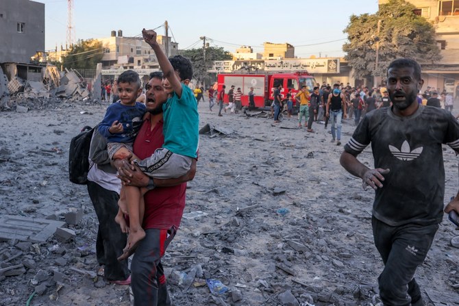 A wounded Palestinian man carries children following a strike in Rafah on the southern Gaza Strip on November 6, 2023, amid the ongoing battles between Israel and the militant group Hamas. (AFP)