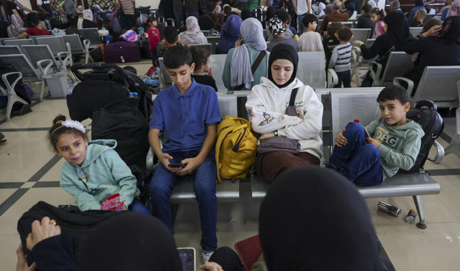 Palestinian dual nationals and foreigners wait to cross the Rafah border crossing with Egypt, in the southern Gaza Strip, on November 7, 2023. (AFP)