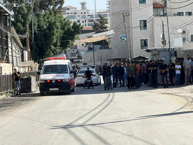 Palestinians wait in front of a hospital during an Israeli raid in Jenin in the Israeli-occupied West Bank. (Reuters)
