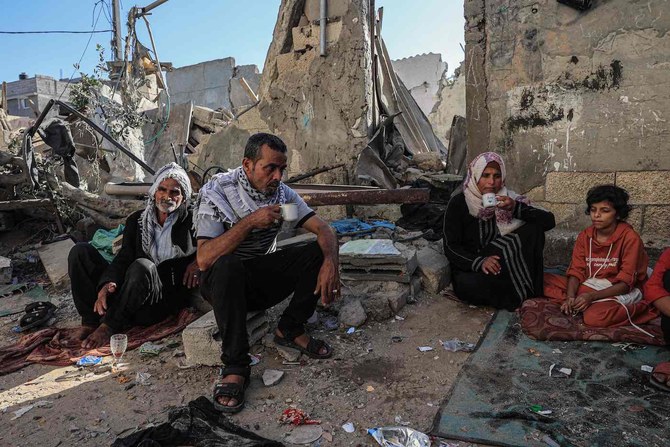 A family drink tea amid the rubble of a building destroyed in Israeli bombing in Rafah in the southern Gaza Strip, on November 7, 2023. (AFP)