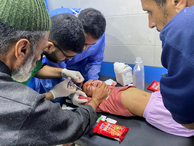 Palestinian girl Orheen Al-Dayah, who was injured in her forehead in an Israeli strike amid the ongoing conflict has her wounds stitched without anesthesia, at Al Shifa hospital in Gaza (REUTERS)