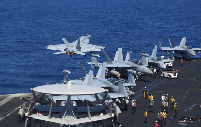 A US FA-18 hornet fighter jet flies past fighter jets and a E-2C Hawkeyes during a routine training aboard US aircraft carrier Theodore Roosevelt in the South China sea on April 10, 2018. (AFP)