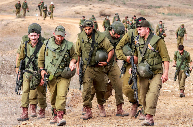 Israeli army soldiers return after searching for human remains following the October 7 attack carried out by Palestinian militants from the Gaza Strip, near a position along the border with southern Israel on November 12, 2023 amid the ongoing battles between Israel and the militant group Hamas. (AFP)