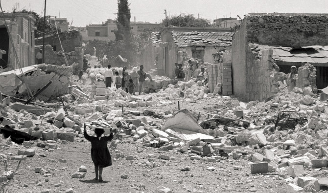 A child carrying a tray of food walks among the ruins of the West Bank city of Kalkilya in the aftermath of the 1967 Six-Day War. (Getty Images)