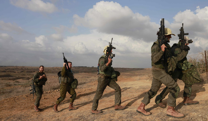 Israeli army soldiers return after searching for human remains following the October 7 attack carried out by Palestinian militants from the Gaza Strip, near a position along the border with southern Israel on November 14, 2023. (AFP)