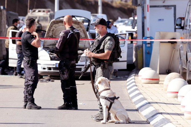 Israeli officers secure scene after attack by gunmen on a checkpoint guarding access to road tunnels linking the Israeli occupied Palestinian West Bank and Jerusalem. (AFP)
