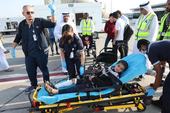 Volunteers transport wounded Palestinian child off the plane upon arrival in Abu Dhabi, after being evacuated from Gaza as part of a UAE humanitarian mission. (AFP)