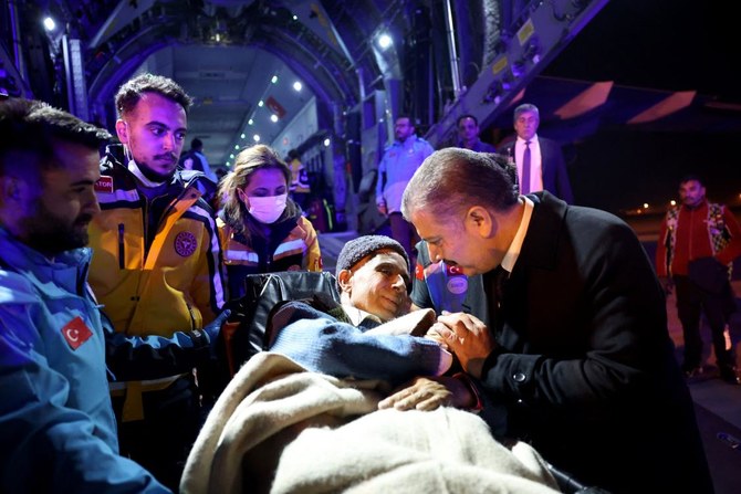 Turkish Health Minister Fahrettin Koca speaks with a Palestinian cancer patient who had arrived at the Esenboga Airport in Ankara last week. (File/AFP)