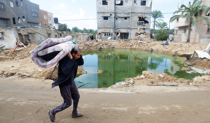 A Palestinian walks past buildings destroyed in Israeli bombardment in the Nusseirat refugee camp, central Gaza Strip. (AP)