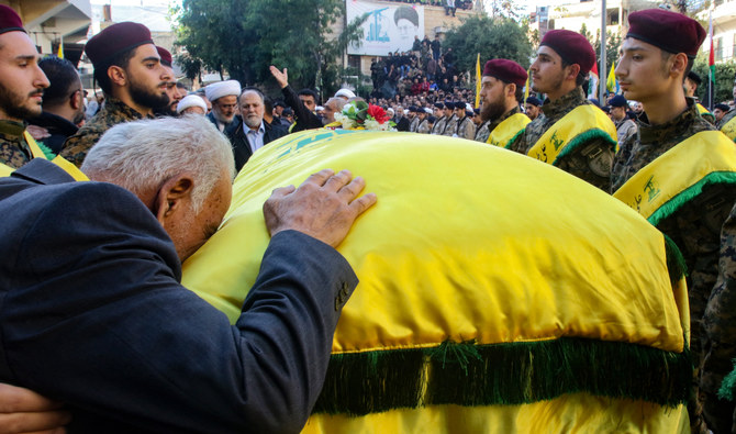 A man mourns over the coffin of Abbas Raad, son of the head of Hezbollah’s parliamentary bloc Mohammed Raad, who was killed in southern Lebanon in cross-border fire with Israeli troops, during his funeral in Jbaa, on November 23, 2023. (AFP)