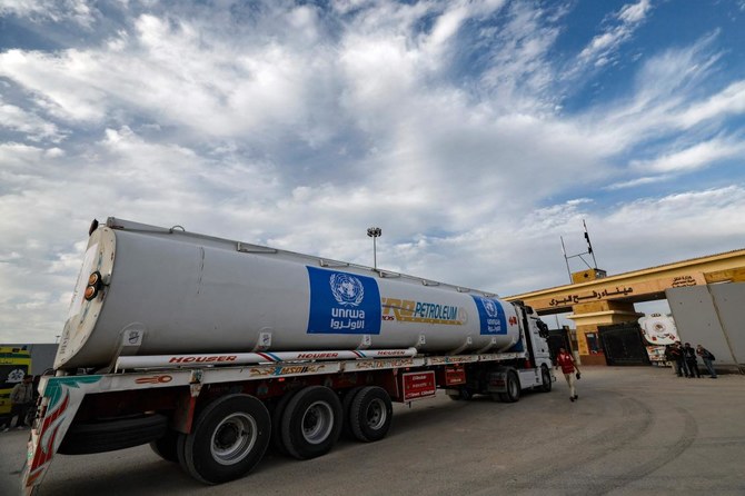 A truck carrying humanitarian aid from the United Nations Relief and Works Agency for Palestine Refugees arrives at the Rafah border crossing on Nov. 22, 2023, a day before a truce starts in the Gaza Strip. (AFP)