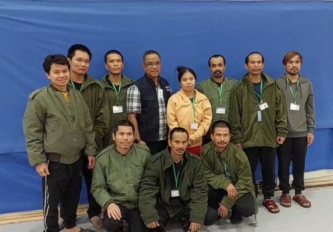 Thai workers taken hostage by Hamas and later released as part of a deal between Israel and Hamas, pose with a member of Thai mission after a medical checkup, in Tel Aviv, in this handout image released on Nov. 25, 2023. (Reuters)
