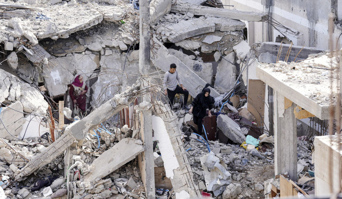 Palestinians visit their destroyed homes in the village of Khuza’a, east of Khan Younis, Gaza Strip. The truce has given some respite to residents. (AP)
