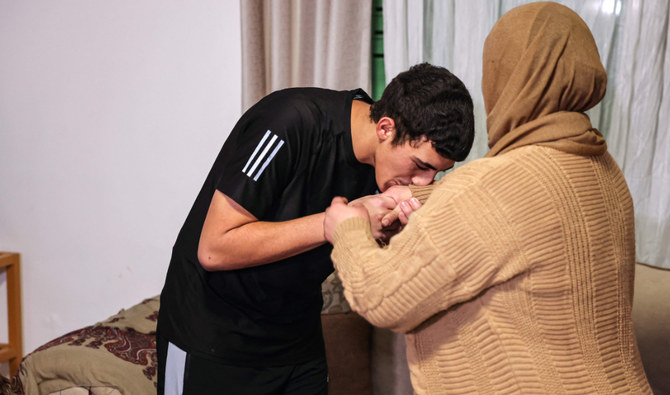 Palestinian Muhammad Abu Al-Humus, former prisoner released from the Israeli jail in exchange for hostages freed by Hamas in Gaza, kisses his mother upon return to his home in east Jerusalem. (AFP)